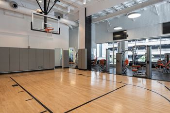 a basketball court in a gym with a basketball hoop and weights at Sky on Main in Kansas City, 64105